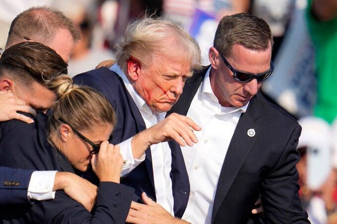 Vành tai phải của ông Trump chảy máu sau khi bị viên đạn xuyên qua. (Ảnh: AP)