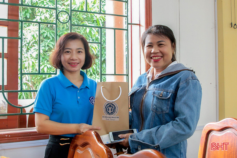 Chị Trần Thị Việt Hương tặng quà của BHXH cho người dân tại hội nghị tuyên truyền chính sách BHXH tự nguyện, BHYT hộ gia đình ở xã Thạch Xuân (huyện Thạch Hà). 1.jpg