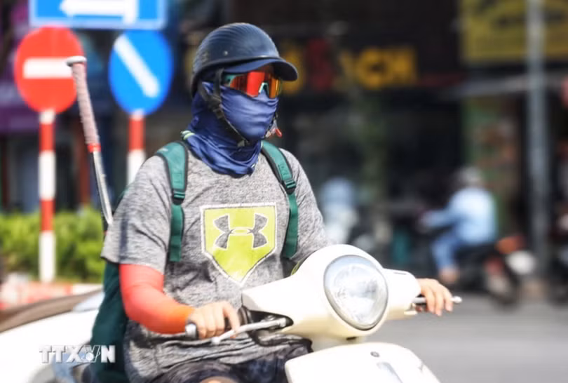 Người dân bịt kín khi ra đường trong ngày nắng nóng để đảm bảo sức khỏe. (Ảnh: TTXVN phát)