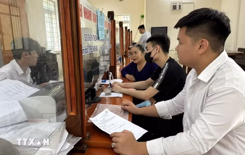 Người dân thực hiện thủ tục hành chính tại Bộ phận tiếp nhận và trả kết quả thủ tục hành chính. (Ảnh: TTXVN phát)