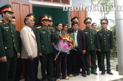 Ông Lâm (người cầm hoa) đứng giữa đồng đội bên ngôi nhà mới