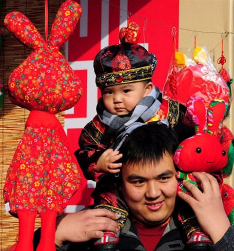 Một người dàn ông cõng cô con gái và những búp bê hình thỏ đi chơi 30 Tết ở chùa tại Bắc Kinh (Trung Quốc). Theo quan niệm của người nước này, năm nay là năm con Thỏ.
