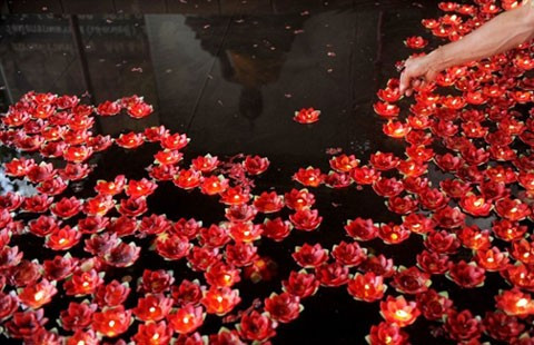 Tại Thái Lan, quốc gia theo Phật giáo, ngày đầu năm âm lịch là một trong những lễ quan trọng. Một nhà sư đang thắp các ngọn hoa nến thả trên hồ nước, cầu nguyện cho năm mới tốt đẹp.