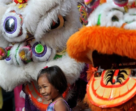 Bé gái Philippines làm duyên bên những con lân rồng.