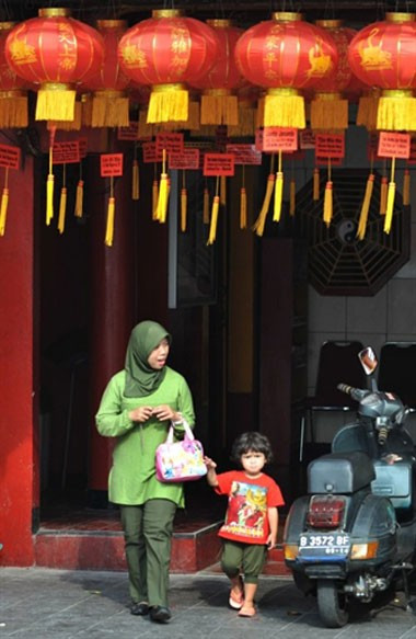 Cộng đồng người Hoa ở Indonesia trang hoàng đón Tết. Em bé này được cùng mẹ đi chùa vào ngày cuối cùng của năm cũ.