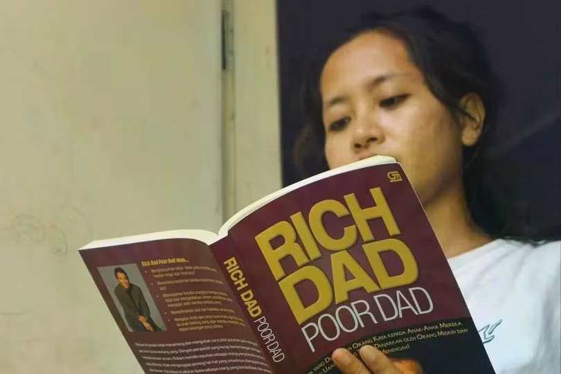 Một phụ nữ trẻ tại Indonesia đọc cuốn Cha giàu, cha nghèo của Robert Kiyosaki. Ảnh: Shutterstock.