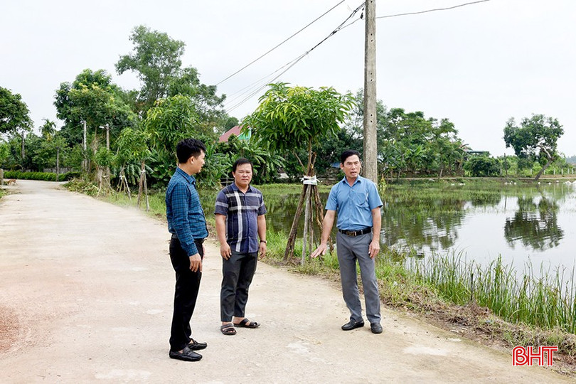 Ông Trần Hậu Lâm - Phó Chủ tịch UBND xã Thạch Ngọc (ngoài cùng bên phải) mô tả độ ngập sâu của trận lụt năm 2010 trên tuyến đường thôn Mộc Hải.