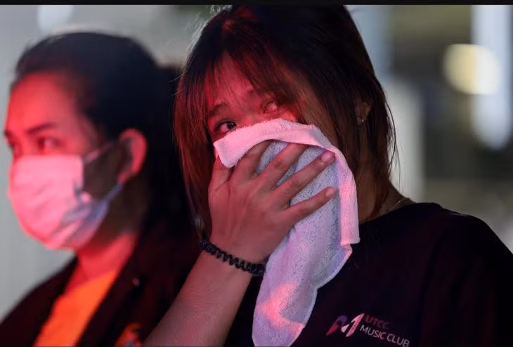 Một cô gái có chị thiệt mạng trong vụ hỏa hoạn tại quán bar ở Bangkok phản ứng gần hiện trường ngày 13-7-2026 - Ảnh: REUTERS