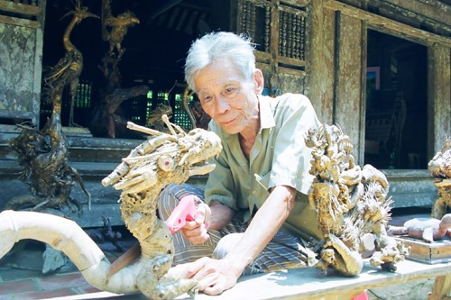 Nghệ nhân Lê Mưu đang "thổi hồn rồng" vào những gốc tre