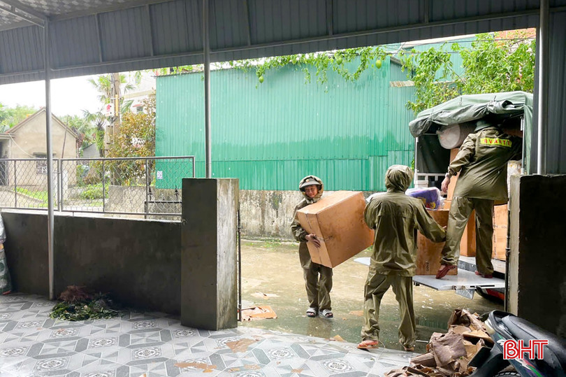 Lực lượng công an và người dân giúp các gia đình bị tốc mái di chuyển đồ đạc đến nơi khô ráo.