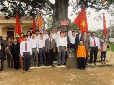Đại biểu, giáo viên và người dân chụp ảnh lưu niệm bên Cây Di sản hàng trăm năm tuổi