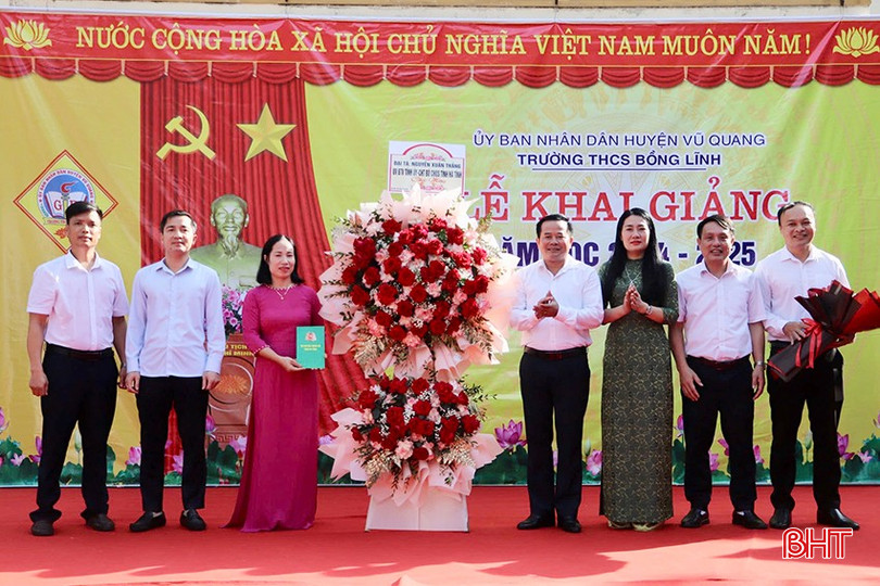 Đại tá Nguyễn Xuân Thắng - Chỉ huy trưởng Bộ CHQS tỉnh và lãnh đạo huyện Vũ Quang tặng hoa chúc mừng tập thể Trường THCS Bồng Lĩnh.