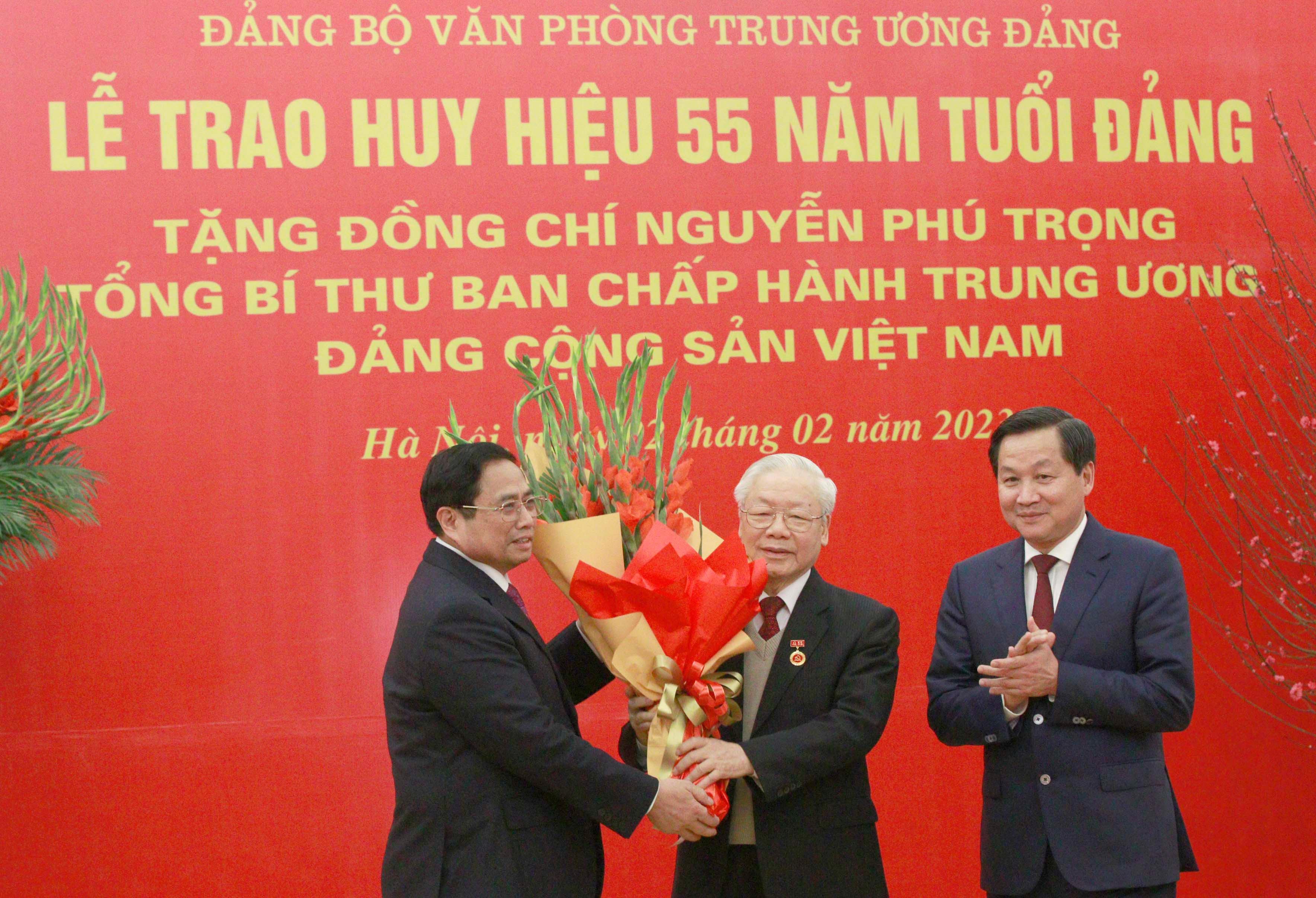 Thủ tướng Chính phủ Phạm Minh Chính và Phó Thủ tướng Chính phủ Lê Minh Khái tặng hoa chúc mừng Tổng Bí thư Nguyễn Phú Trọng nhận Huy hiệu 55 năm tuổi Đảng. Ảnh: Báo điện tử Đảng Cộng sản.