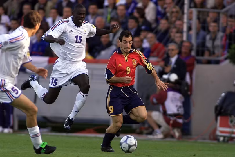 Lilian Thuram (số 15) và Pedro Munitis (số 9) trong trận tứ kết Euro 2000 giữa Pháp và Tây Ban Nha trên sân Jan Breydel, Bruges, Bỉ ngày 25/6/2000. Ảnh: AFP