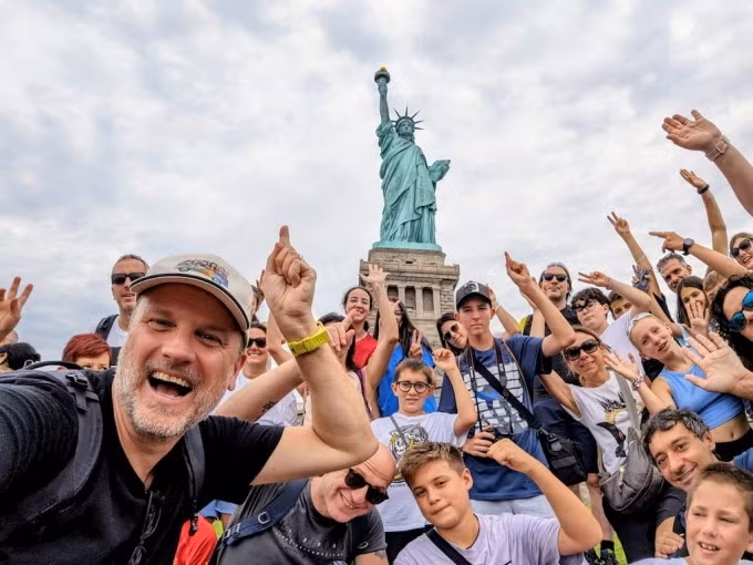 Du khách chụp ảnh tượng Nữ thần Tự do ở New York. Ảnh: Bambini