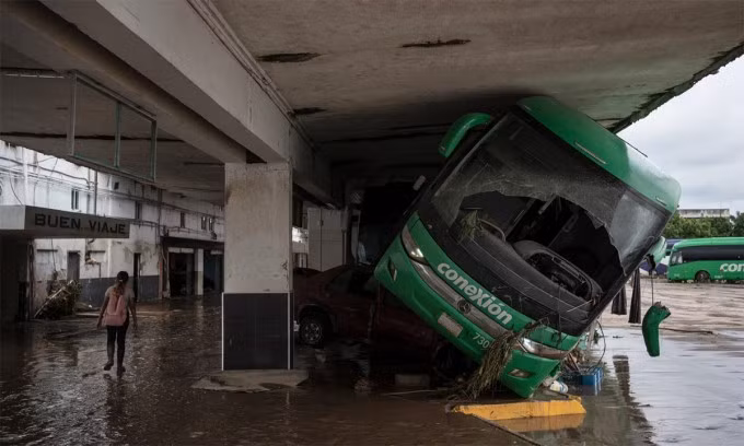 Xe buýt bị nước lũ cuốn vào nhà chờ tại Poza Rica, bang Veracruz, Mexico ngày 11/10. Ảnh: AP