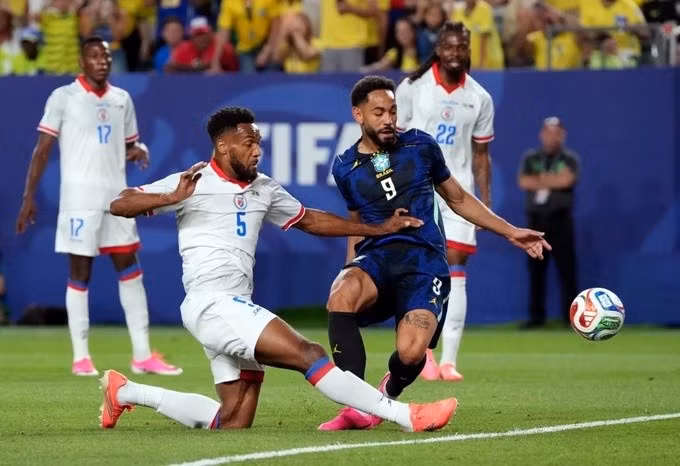 Hậu vệ Haiti (trắng) truy cản Cunha (số 9, xanh) trên sân Lincoln Financial Field, Philadelphia, bang Pennsylvania, Mỹ ngày 20/6. Ảnh: Reuters