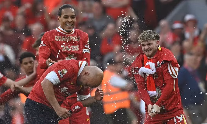 Cầu thủ Liverpool xịt bọt từ các chai champagne lên người HLV Arne Slot, sau trận thắng Tottenham ở vòng 34 Ngoại hạng Anh trên sân Anfield, thành phố Liverpool, Vương quốc Anh ngày 27/4/2025. Ảnh: AFP