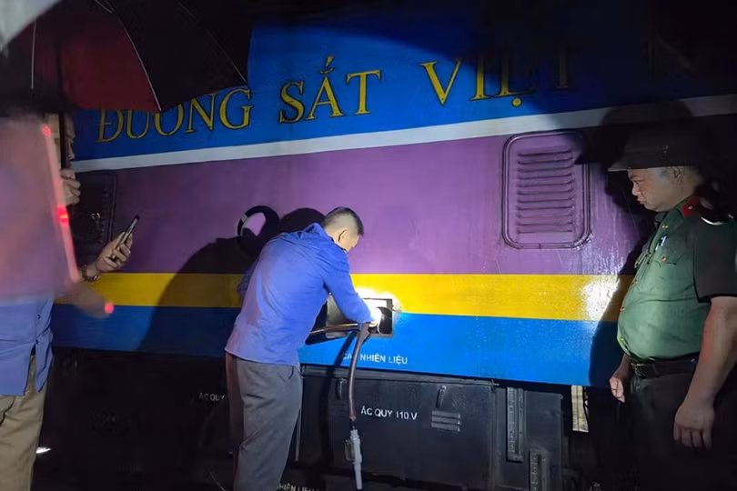 Cảnh sát bắt quả tang một nghi phạm đang hút trộm dầu tại đầu máy tàu hỏa ở Ga Vinh hồi cuối tháng 7. Ảnh: Hòa Vang