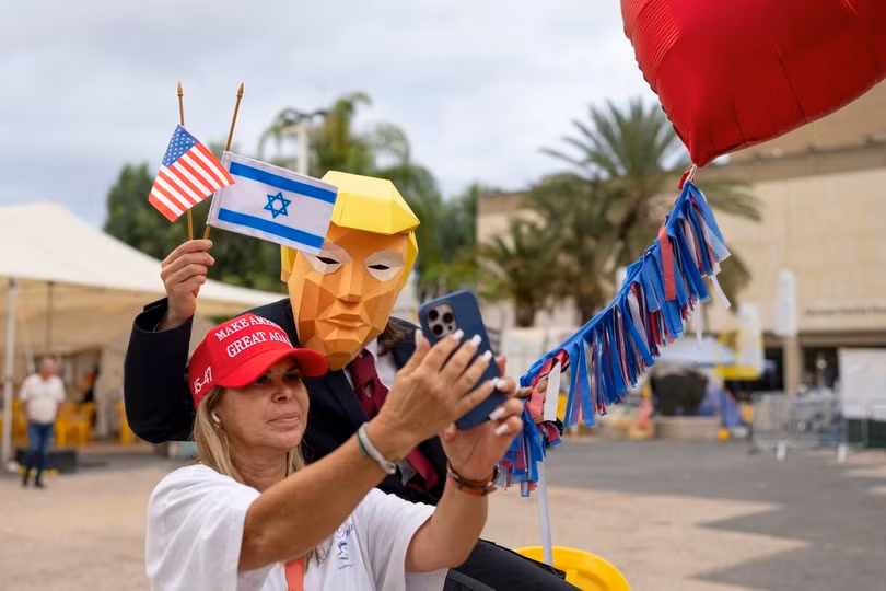 Người phụ nữ chụp ảnh cùng người đeo mặt nạ ông Trump ở quảng trường.
