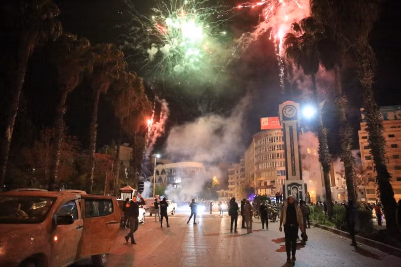 Người dân bắn pháo hoa ở quảng trường chính của thành phố Homs lớn thứ ba Syria sáng 8/12, sau khi lực lượng phiến quân tiến vào thành phố.