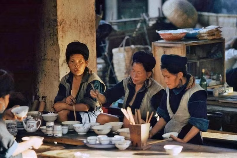 Grumpe ghi lại khoảnh khắc người H'Mông ăn sáng giữa phiên chợ vùng cao. Ông đặc biệt ấn tượng với những bộ trang phục nhuộm chàm thủ công, đôi khuyên tai bạc cỡ lớn của phụ nữ, tục cạo lông mày và chiếc khăn đội đầu màu đỏ đặc trưng của người Dao.