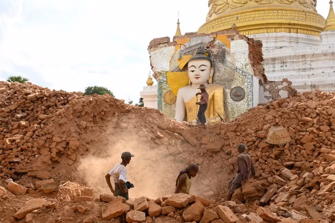 Người dân dọn dẹp đống đổ nát ở chùa Lawkatharaphu bị hư hại ở Mandalay, Myanmar, ngày 12/4. Ảnh: AFP