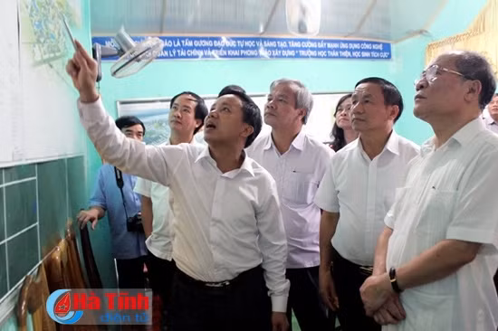 Chủ tịch Quốc hội Nguyễn Sinh Hùng và lãnh đạo tỉnh nghe lãnh đạo huyện báo cáo quy hoạch khu đô thị Kỳ Đồng - trung tâm hành chính huyện Kỳ Anh. Ảnh: Thăng Long