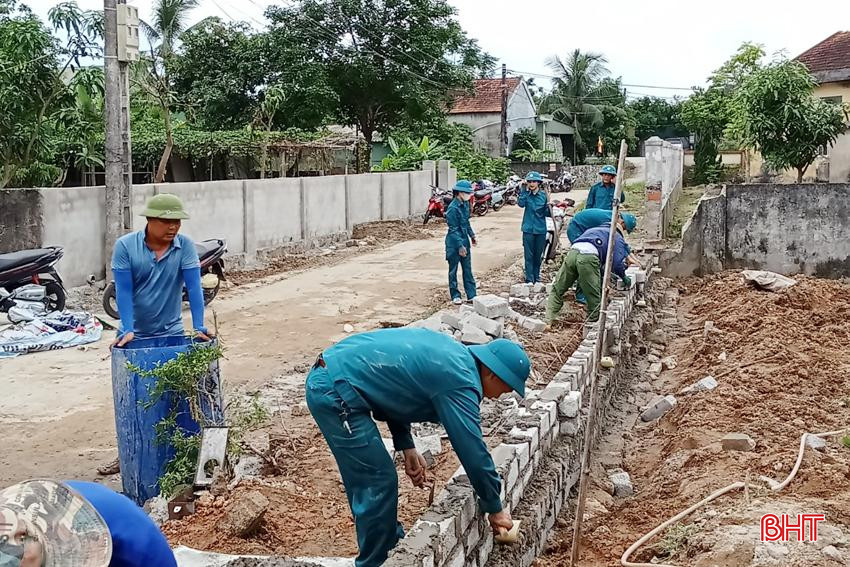 Lực lượng dân quân tham gia giúp người dân các thôn xây lại tường rào sau khi hiến đất.