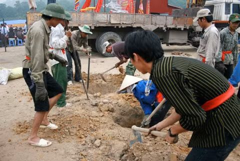 Từ sáng sớm, hàng nghìn người đã đổ về khu đúc tượng cạnh Học viện Phật giáo VN (Sóc Sơn, Hà Nội). Theo lịch âm là ngày "trùng cửu", ngày có ý nghĩa thiêng liêng đặc biệt, rất thích hợp để tiến hành đúc tượng Thánh Gióng - Đức Thánh Phù Đổng Thiên vương. Một mô hình thu nhỏ đặt cạnh khu đúc tượng để phật tử làm lễ, chiêm bái. Khi hoàn thành, tượng cao gần 11 m, độ vươn chéo lên trời khoảng 16 m. Rất nhiều người góp trang sức bằng kim loại quý để hòa cùng dòng đồng nóng chảy lúc đổ vào khuôn. Tại khu đất được cách ly cạnh đó, hai chiếc khuôn của phần đầu ngựa và thân trên Thánh Gióng đang gấp rút được hoàn tất những khâu cuối cùng. Đây là 2 thớt đầu tiên được đúc của tượng đài. Một số chi tiết khác của tượng đài cũng được làm trong mẻ đầu tiên. Hàng trăm thanh đồng đỏ nguyên chất được nung chảy trong lò ga hơn 1.000 độ C. Theo các nghệ nhân, thời gian từ lúc nấu đến lúc đổ đồng mất hơn 2 giờ. Người nghệ nhân cẩn thận trát kín mạch và tạo miệng khuôn để đổ đồng nóng chảy vào. Sau 2 giờ nung, mẻ đồng nóng chảy đổ ra... ... trong khi các nghệ nhân kính cẩn thắp hương mong mọi việc suôn sẻ. Bên ngoài hàng rào, hàng nghìn người chen lấn mong được vào chiêm ngưỡng cận cảnh. Tới dự buổi lễ sáng nay có nguyên Tổng bí thư Đỗ Mười, cùng nhiều vị lãnh đạo. Ngay trước thời khắc 9h9, hòa thượng Thích Thanh Tứ, Phó chủ tịch Trung ương hội Phật giáo VN(người đeo tràng hạt) cùng nhiều quan chức tiến vào khu đúc tượng. Hàng trăm món đồ kim loại quý được thả vào khuôn... ... trước khi dòng đồng đỏ nóng chảy được rót. Theo các nghệ nhân, công đoạn khó nhất của quá trình đúc tượng là khâu làm khuôn: mất 2 tháng. Khuôn phải làm sao để toát lên được thần thái của Thánh Gióng và toàn bộ hoa văn, họa tiết tinh xảo của tượng với đúng tỉ lệ 1:1. Sau khi đổ đầy đồng vào khuôn, cần tới 4 ngày để làm nguội tự nhiên rồi mới phá khuôn.