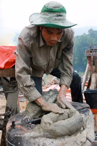 Từ sáng sớm, hàng nghìn người đã đổ về khu đúc tượng cạnh Học viện Phật giáo VN (Sóc Sơn, Hà Nội). Theo lịch âm là ngày "trùng cửu", ngày có ý nghĩa thiêng liêng đặc biệt, rất thích hợp để tiến hành đúc tượng Thánh Gióng - Đức Thánh Phù Đổng Thiên vương. Một mô hình thu nhỏ đặt cạnh khu đúc tượng để phật tử làm lễ, chiêm bái. Khi hoàn thành, tượng cao gần 11 m, độ vươn chéo lên trời khoảng 16 m. Rất nhiều người góp trang sức bằng kim loại quý để hòa cùng dòng đồng nóng chảy lúc đổ vào khuôn. Tại khu đất được cách ly cạnh đó, hai chiếc khuôn của phần đầu ngựa và thân trên Thánh Gióng đang gấp rút được hoàn tất những khâu cuối cùng. Đây là 2 thớt đầu tiên được đúc của tượng đài. Một số chi tiết khác của tượng đài cũng được làm trong mẻ đầu tiên. Hàng trăm thanh đồng đỏ nguyên chất được nung chảy trong lò ga hơn 1.000 độ C. Theo các nghệ nhân, thời gian từ lúc nấu đến lúc đổ đồng mất hơn 2 giờ. Người nghệ nhân cẩn thận trát kín mạch và tạo miệng khuôn để đổ đồng nóng chảy vào. Sau 2 giờ nung, mẻ đồng nóng chảy đổ ra... ... trong khi các nghệ nhân kính cẩn thắp hương mong mọi việc suôn sẻ. Bên ngoài hàng rào, hàng nghìn người chen lấn mong được vào chiêm ngưỡng cận cảnh. Tới dự buổi lễ sáng nay có nguyên Tổng bí thư Đỗ Mười, cùng nhiều vị lãnh đạo. Ngay trước thời khắc 9h9, hòa thượng Thích Thanh Tứ, Phó chủ tịch Trung ương hội Phật giáo VN(người đeo tràng hạt) cùng nhiều quan chức tiến vào khu đúc tượng. Hàng trăm món đồ kim loại quý được thả vào khuôn... ... trước khi dòng đồng đỏ nóng chảy được rót. Theo các nghệ nhân, công đoạn khó nhất của quá trình đúc tượng là khâu làm khuôn: mất 2 tháng. Khuôn phải làm sao để toát lên được thần thái của Thánh Gióng và toàn bộ hoa văn, họa tiết tinh xảo của tượng với đúng tỉ lệ 1:1. Sau khi đổ đầy đồng vào khuôn, cần tới 4 ngày để làm nguội tự nhiên rồi mới phá khuôn.