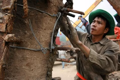 Từ sáng sớm, hàng nghìn người đã đổ về khu đúc tượng cạnh Học viện Phật giáo VN (Sóc Sơn, Hà Nội). Theo lịch âm là ngày "trùng cửu", ngày có ý nghĩa thiêng liêng đặc biệt, rất thích hợp để tiến hành đúc tượng Thánh Gióng - Đức Thánh Phù Đổng Thiên vương. Một mô hình thu nhỏ đặt cạnh khu đúc tượng để phật tử làm lễ, chiêm bái. Khi hoàn thành, tượng cao gần 11 m, độ vươn chéo lên trời khoảng 16 m. Rất nhiều người góp trang sức bằng kim loại quý để hòa cùng dòng đồng nóng chảy lúc đổ vào khuôn. Tại khu đất được cách ly cạnh đó, hai chiếc khuôn của phần đầu ngựa và thân trên Thánh Gióng đang gấp rút được hoàn tất những khâu cuối cùng. Đây là 2 thớt đầu tiên được đúc của tượng đài. Một số chi tiết khác của tượng đài cũng được làm trong mẻ đầu tiên. Hàng trăm thanh đồng đỏ nguyên chất được nung chảy trong lò ga hơn 1.000 độ C. Theo các nghệ nhân, thời gian từ lúc nấu đến lúc đổ đồng mất hơn 2 giờ. Người nghệ nhân cẩn thận trát kín mạch và tạo miệng khuôn để đổ đồng nóng chảy vào. Sau 2 giờ nung, mẻ đồng nóng chảy đổ ra... ... trong khi các nghệ nhân kính cẩn thắp hương mong mọi việc suôn sẻ. Bên ngoài hàng rào, hàng nghìn người chen lấn mong được vào chiêm ngưỡng cận cảnh. Tới dự buổi lễ sáng nay có nguyên Tổng bí thư Đỗ Mười, cùng nhiều vị lãnh đạo. Ngay trước thời khắc 9h9, hòa thượng Thích Thanh Tứ, Phó chủ tịch Trung ương hội Phật giáo VN(người đeo tràng hạt) cùng nhiều quan chức tiến vào khu đúc tượng. Hàng trăm món đồ kim loại quý được thả vào khuôn... ... trước khi dòng đồng đỏ nóng chảy được rót. Theo các nghệ nhân, công đoạn khó nhất của quá trình đúc tượng là khâu làm khuôn: mất 2 tháng. Khuôn phải làm sao để toát lên được thần thái của Thánh Gióng và toàn bộ hoa văn, họa tiết tinh xảo của tượng với đúng tỉ lệ 1:1. Sau khi đổ đầy đồng vào khuôn, cần tới 4 ngày để làm nguội tự nhiên rồi mới phá khuôn.