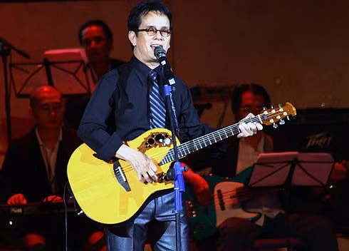 Nhạc sĩ Đức Huy với hình ảnh quen thuộc, vừa đàn guitar vừa hát "Và tôi cũng yêu em".